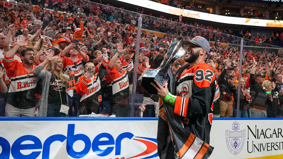 Dhane Smith of the Buffalo Bandits carries the trophy after winning the NLL Championship in 2023. | Photo by Kevin Hoffman/Getty Images for NLL