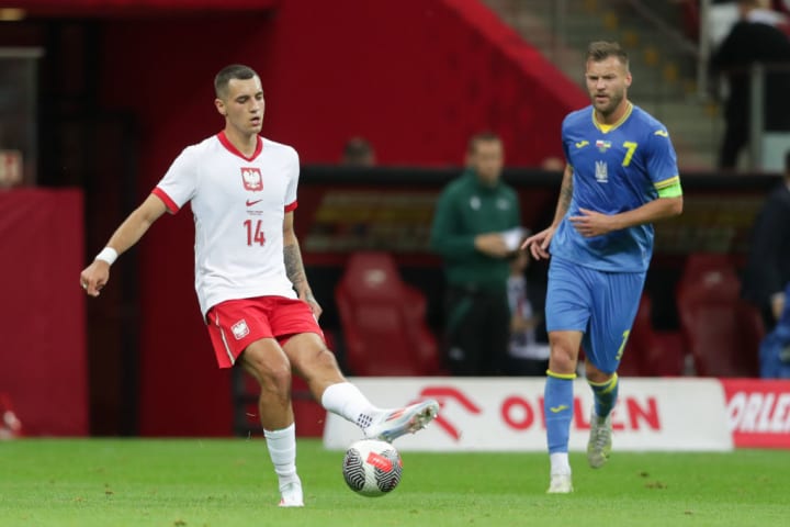 Jakub Kiwior of Poland (L) and Andriy Yarmolenko of Ukraine...