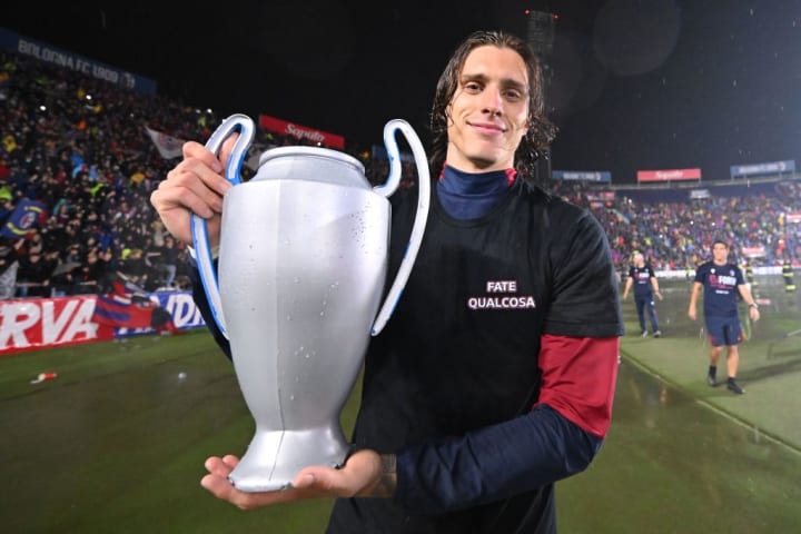 Riccardo Calafiori holding a model Champions League trophy