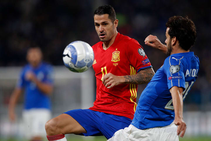 Spain Vitolo, left, is challenged by Italy Marco Parolo...