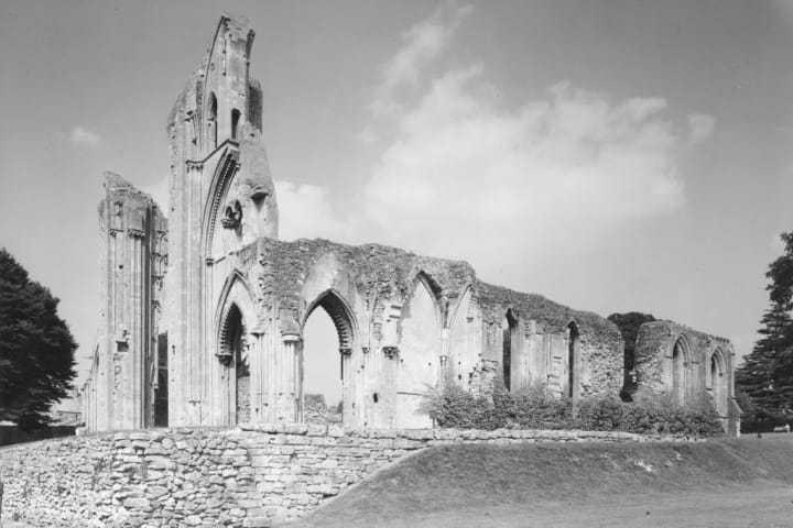 Black and white photo of the ruins of Glastonbury Abbey.