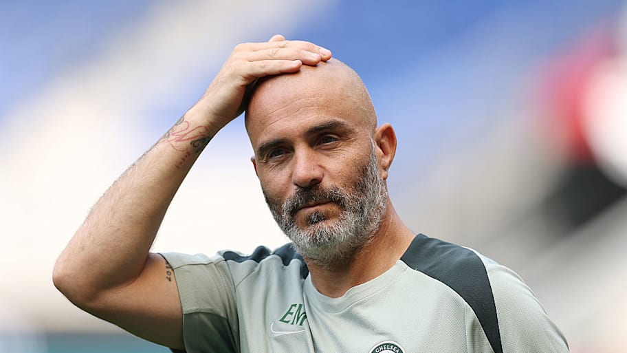 Enzo Maresca scratching his bald scalp.