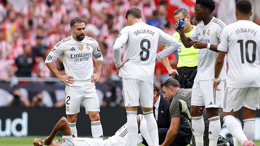 Eder Militao lies prone on the ground receiving treatment.