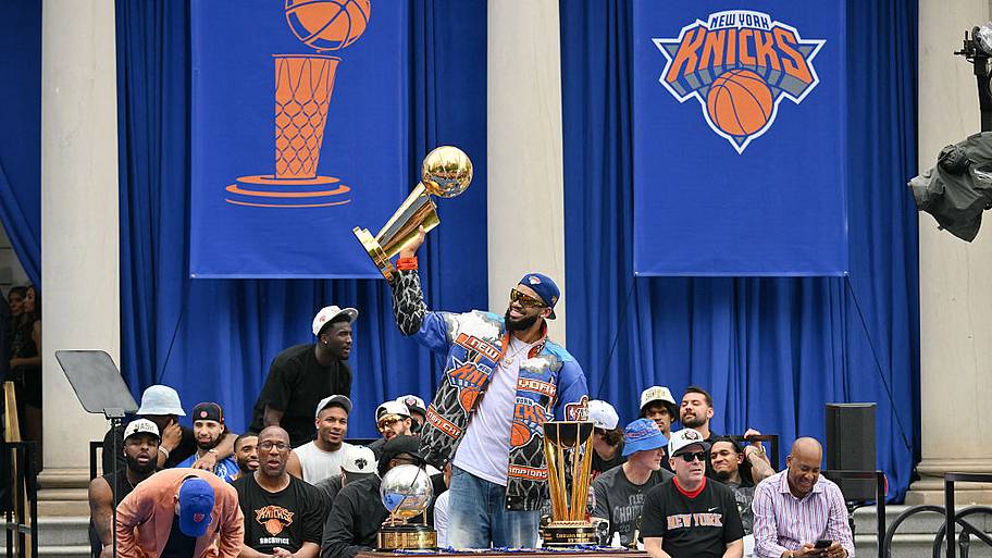 Karl-Anthony Towns of the New York Knicks holds the Larry O'Brien Championship Trophy during a ceremony at City Hall.