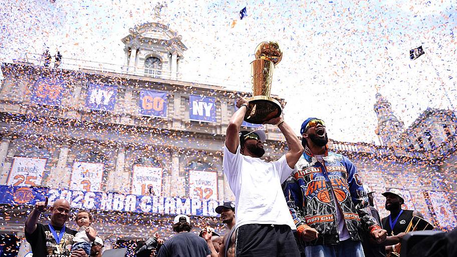 Jalen Brunson and Karl-Anthony Towns of the New York Knicks celebrate with the Larry O'Brien Championship Trophy.