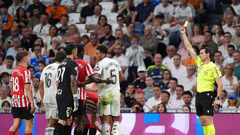La Liga referee shows a yellow card.