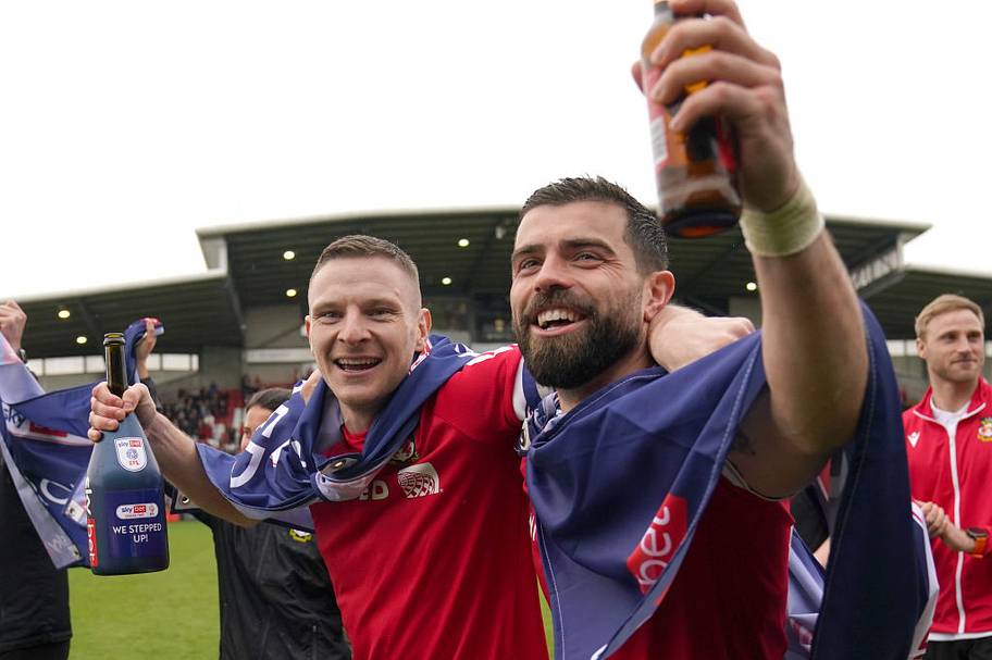 Paul Mullin and Elliot Lee on the pitch celebrating promotion to League One.