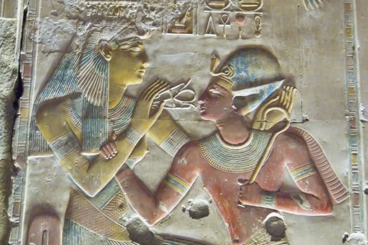 Egyptian stone carving of Pharaoh Seti I (on right) with the Goddess Hathor/