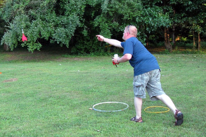 A man throwing lawn darts. 