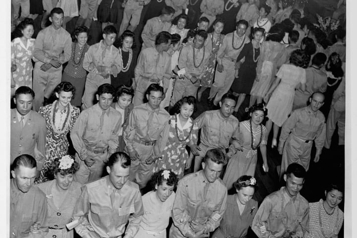 Japanese-American soldiers and their dates at a dance in 1944