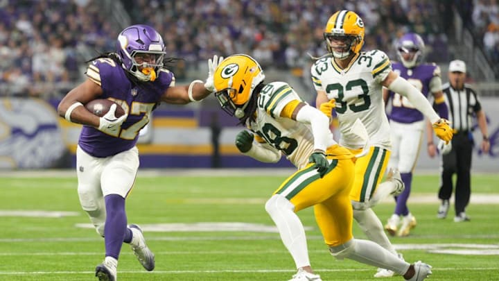 Jan 4, 2026; Minneapolis, Minnesota, USA; Minnesota Vikings running back Jordan Mason (27) runs the ball against Green Bay Packers cornerback Trevon Diggs (28) during the second quarter at U.S. Bank Stadium. Mandatory Credit: Matt Blewett-Imagn Images