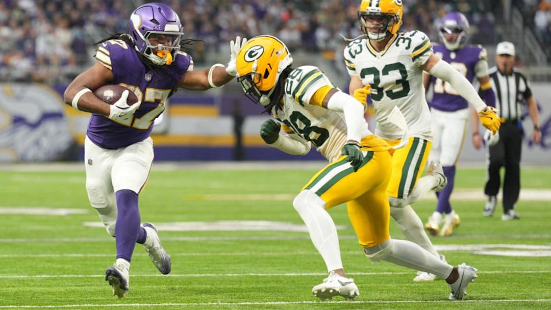 Jan 4, 2026; Minneapolis, Minnesota, USA; Minnesota Vikings running back Jordan Mason (27) runs the ball against Green Bay Packers cornerback Trevon Diggs (28) during the second quarter at U.S. Bank Stadium. Mandatory Credit: Matt Blewett-Imagn Images