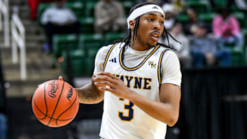 Wayne Memorial's Carlos Medlock Jr. moves the ball against Flint Carman-Ainsworth during the second quarter in the Division 1 state semifinal on Friday, March 14, 2025, at the Breslin Center in East Lansing.
