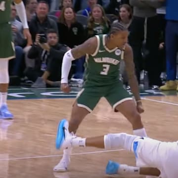 Kevin Porter Jr. stands over Rudy Gobert with his fist clenched.