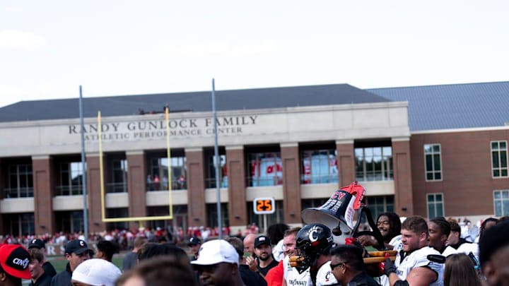 Cincinnati Bearcats carry off the victory bell after defeating the Miami Redhawks at Yager Stadium in Cincinnati on Saturday, Sept. 14, 2024.