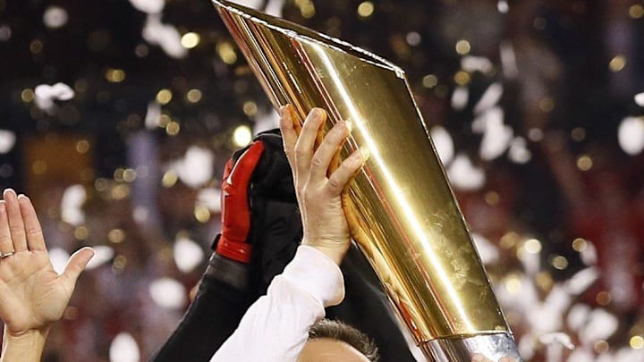 Ohio State coach Urban Meyer hoists the trophy following a 42-20 win over Oregon in the College Football Playoff championship on Jan. 12, 2015.