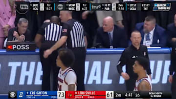 Referees discuss a technical foul called on Louisville head coach Pat Kelsey.