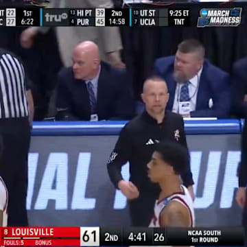 Referees discuss a technical foul called on Louisville head coach Pat Kelsey.