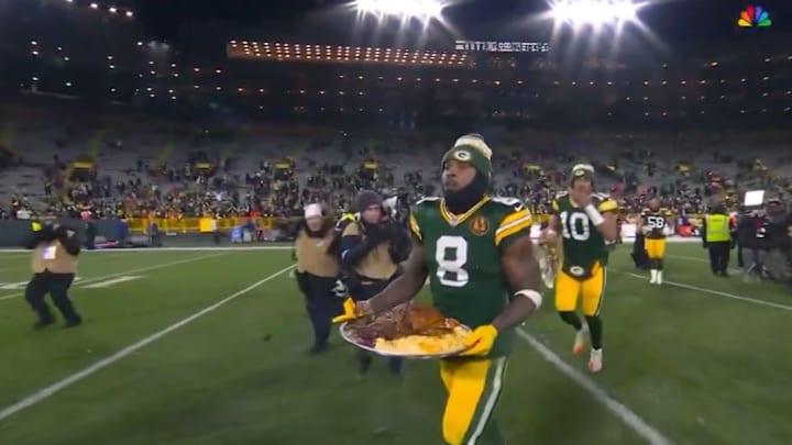 Josh Jacobs carrying Thanksgiving Dinner back to the locker room after the Packers beat the Dolphins.