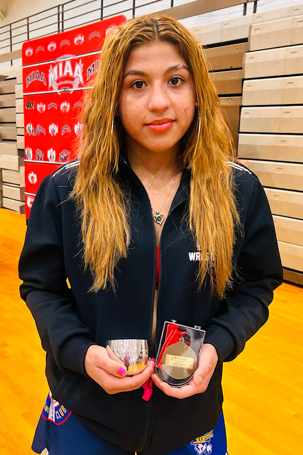 Taina Fernandez shows off her Outstanding Wrestler Award and championship Gold Medal.