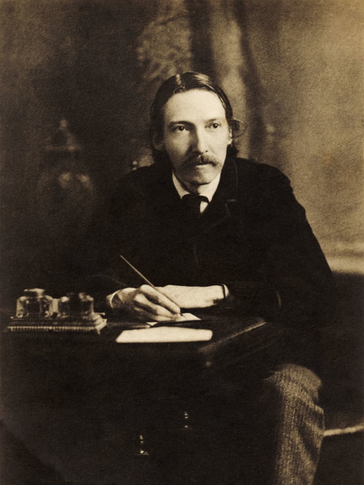 Robert Louis Stevenson, writing at his desk. English author