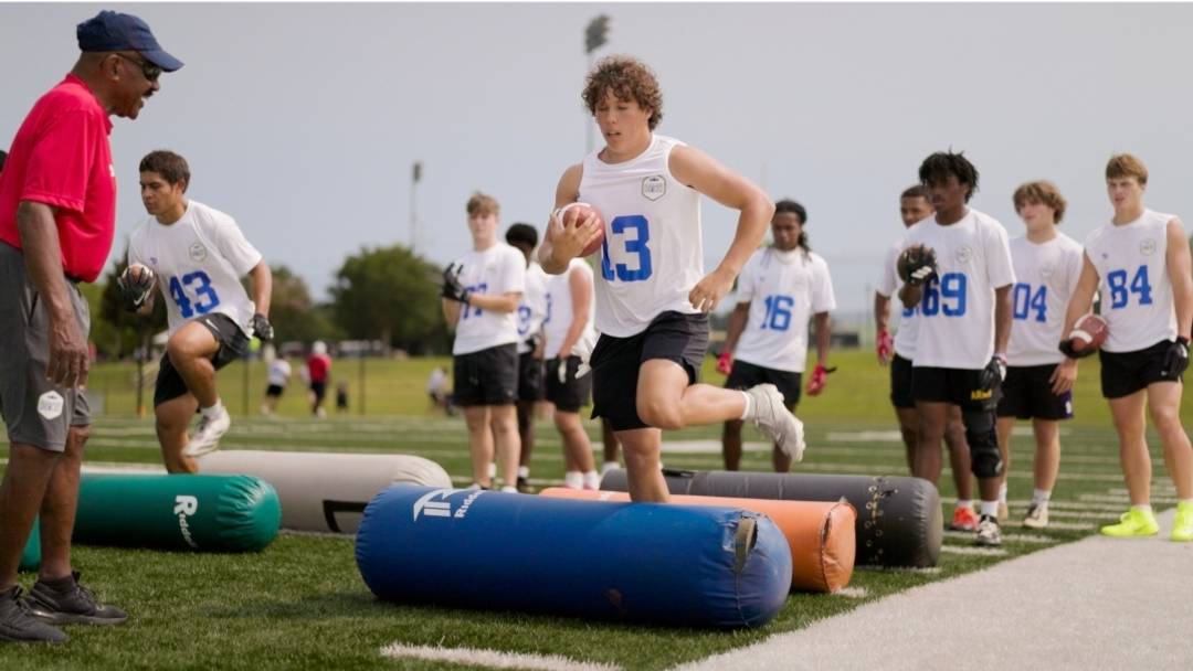 Boys tackle athletes compete in drills under the watchful eye of coaches during the National Summer Showcase in Williamsburg, Virginia.