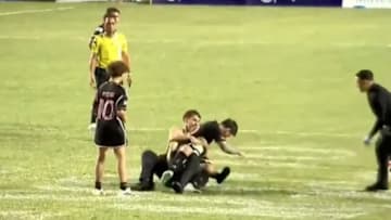 Messi wird von einem Fan niedergerungen