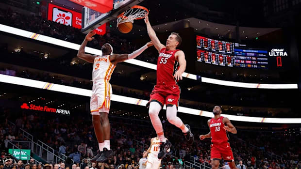 Miami Heat guard Duncan Robinson dunks it past Atlanta Hawks guard Caris Levert, with Heat guard Alec Burks trailing.
