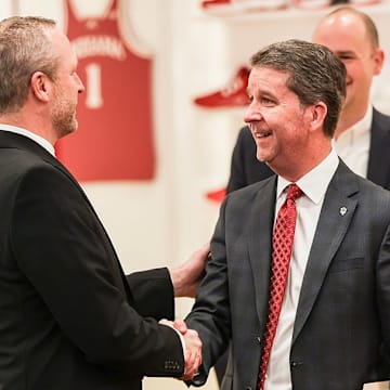 New Indiana basketball coach Darian DeVries (left) shakes hands with Indiana athletic director Scott Dolson.