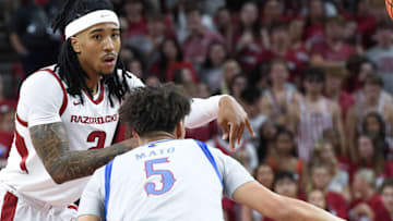 Arkansas Razorbacks guard Boogie Fland makes a pass defended by Kansas Jayhawks Zeke Mayo at Bud Walton Arena in Fayetteville, Ark.
