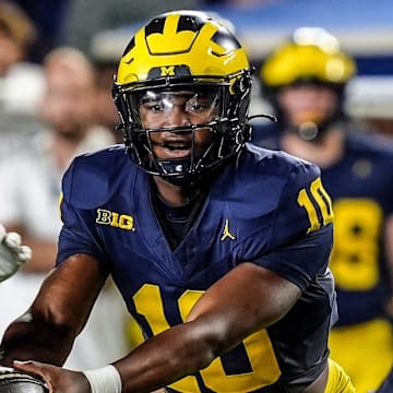 Michigan quarterback Alex Orji (10) hands the ball to Michigan running back Kalel Mullings (20) during the first half against Fresno State at Michigan Stadium at Michigan Stadium in Ann Arbor on Saturday, Aug. 31, 2024.