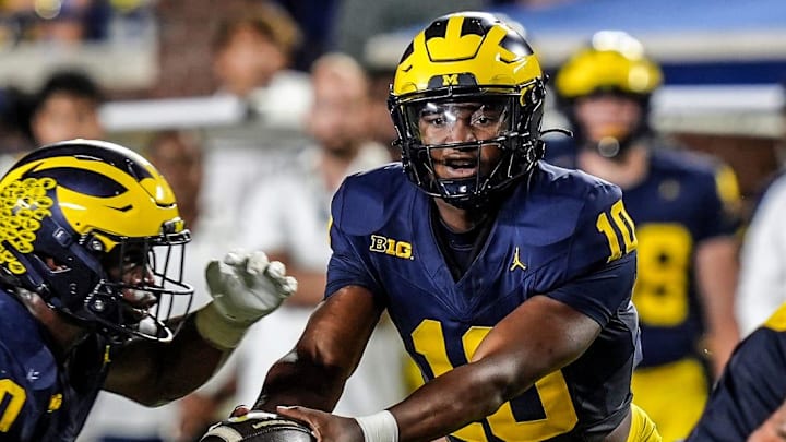 Michigan quarterback Alex Orji (10) hands the ball to Michigan running back Kalel Mullings (20) during the first half against Fresno State at Michigan Stadium at Michigan Stadium in Ann Arbor on Saturday, Aug. 31, 2024.