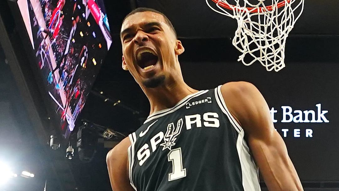 Apr 6, 2026; San Antonio, Texas, USA; San Antonio Spurs forward Victor Wembanyama (1) reacts after dunking ahead of Philadelphia 76ers forwards Justin Edwards (11) and Dominick Barlow (25) during the first half against the Philadelphia 76ers at Frost Bank Center. Mandatory Credit: Scott Wachter-Imagn Images