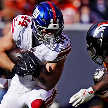 Oct 19, 2025; Denver, Colorado, USA; New York Giants running back Cam Skattebo (44) gets hit by Denver Broncos linebacker Dre Greenlaw (57) and cornerback Riley Moss (21).