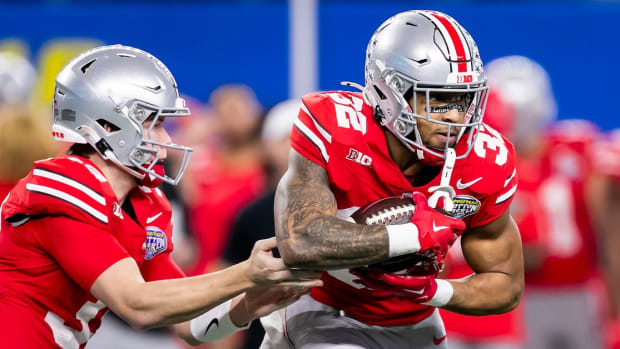 Ohio State QB hands the ball of to the Ohio State running back.