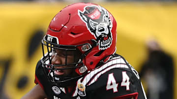 Dec 30, 2022; Charlotte, NC, USA; Maryland Terrapins quarterback Taulia Tagovailoa (3) scrambles as North Carolina State Wolfpack defensive lineman Brandon Cleveland (44) defends in the fourth quarter in the 2022 Duke's Mayo Bowl at Bank of America Stadium. Mandatory Credit: Bob Donnan-Imagn Images