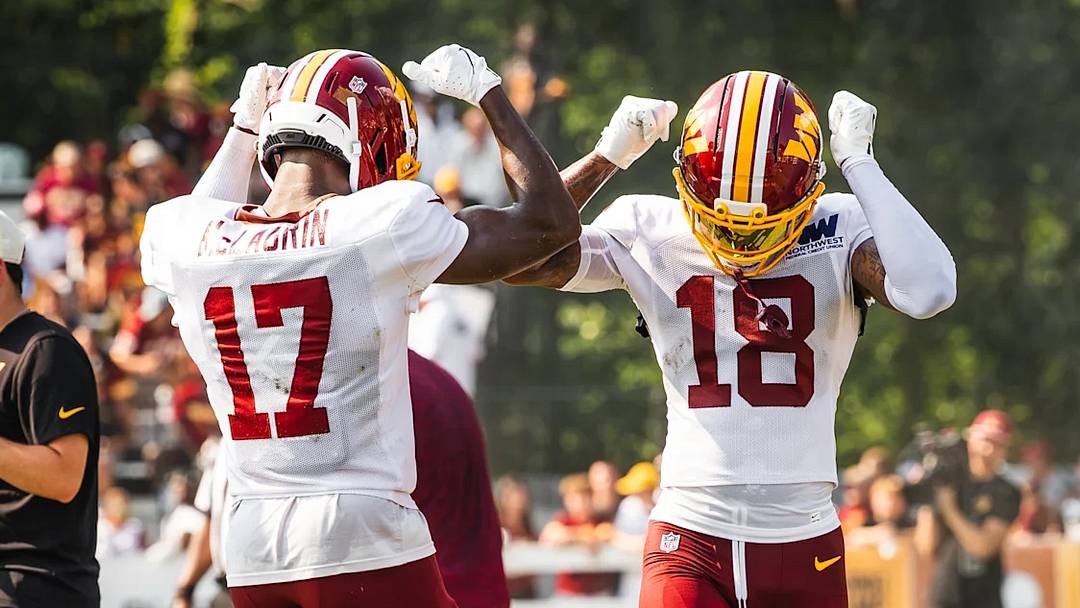 Washington Commanders wide receivers Terry McLaurin (17) and Stefon Diggs (18) celebrate together during training camp practice in Ashburn, Virginia.