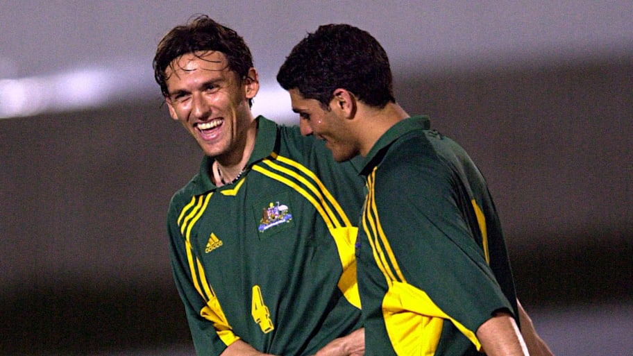 Tony Popovic and John Aloisi of Australia celebrate scoring a goal against Tonga.