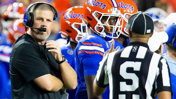 Florida head coach Billy Napier talks with a sidelines official.