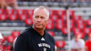 Aug 28, 2025; Raleigh, North Carolina, USA; North Carolina State Wolfpack head coach Dave Doeren walks among his players during the warmups prior to the game against East Carolina Pirates at Carter-Finley Stadium. Mandatory Credit: Jaylynn Nash-Imagn Images