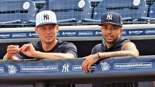 Yankees relievers Will Warren, left, and Devin Williams standing on top row of dugout