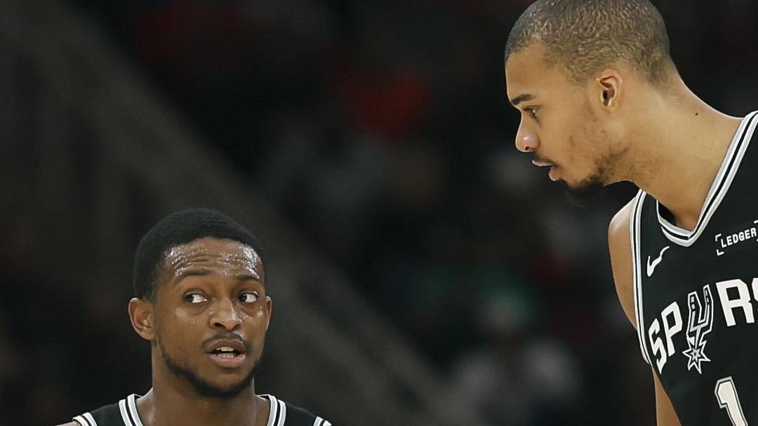 Jan 28, 2026; Houston, Texas, USA; San Antonio Spurs guard De'aaron Fox (4) talks with forward Victor Wembanyama (1) on the court during the second quarter against the Houston Rockets at Toyota Center. Mandatory Credit: Troy Taormina-Imagn Images