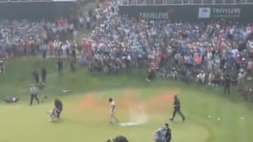 Protesters run onto the 18th green at the 2024 Travelers Championship.
