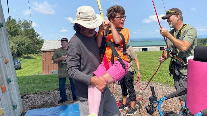 Jim Williams assisting an active North Country Recreation participant, Emily, with the rock wall. Jim Williams assisting an active North Country Recreation participant, Emily, with the rock wall.