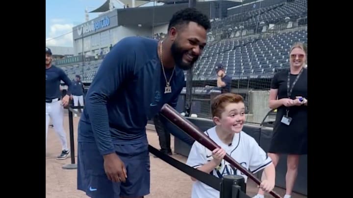 Junior Caminero gives a young fan his bat. Junior Caminero gives a young fan his bat.