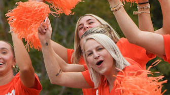 Grand Marshal Amy Smith, the Gymnastics team head coach, cheers and waves with athletes during Clemson University's 50th First Friday parade in Clemson, S.C. Friday, September 6, 2024. Clemson plays Appalachian State September 7.