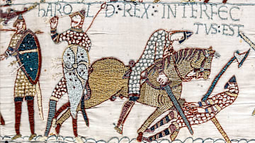 Harold (second from left) grasps the arrow that is apparently in his eye.