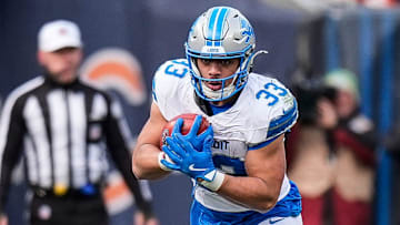 Detroit Lions running back Sione Vaki (33) runs against Chicago Bears linebacker Amen Ogbongbemiga (45) and defensive end Jacob Martin (55) during the second half at Soldier Field in Chicago, Ill. on Sunday, Dec. 22, 2024.