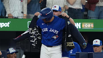 Oct 12, 2025; Toronto, Ontario, CAN; Toronto Blue Jays right fielder George Springer (4) is presented with the “home run jacket” after hitting a solo home run  in the first inning during game one of the ALCS round for the 2025 MLB playoffs against the Seattle Mariners at Rogers Centre. Mandatory Credit: Nick Turchiaro-Imagn Images