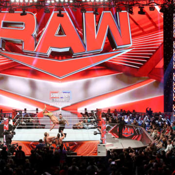 A look at a WWE Monday Night Raw match from afar, with a dive to the outside.